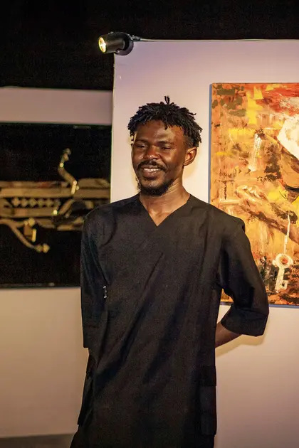 A visitor standing among paintings at KAFART 2023.